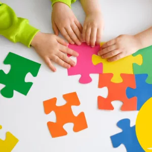 Pictures of children's hands, playing with a giant colourful puzzle
