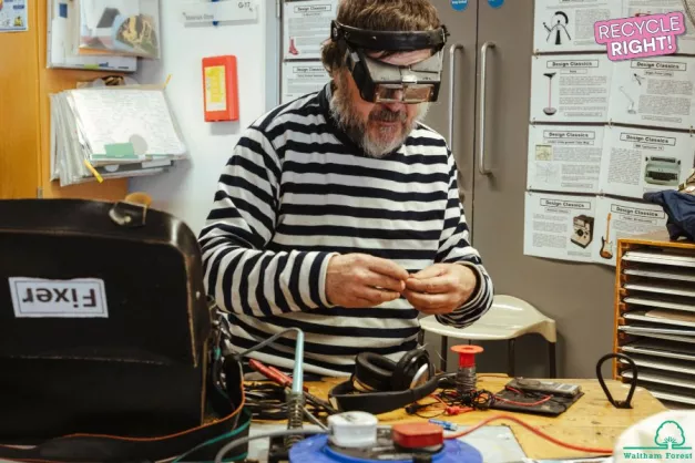 A man in goggles fixing electrical items