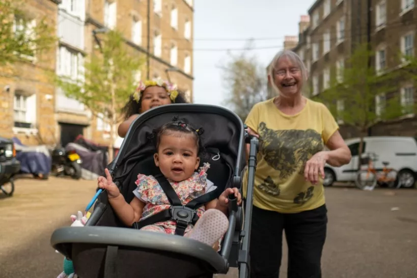 baby in pushchair with child and elderly woman behind 