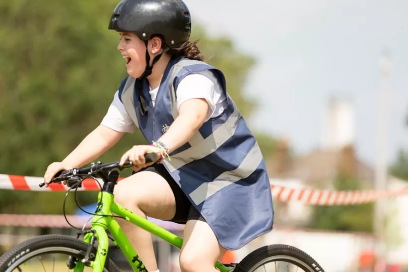 Young girl happily cycling  